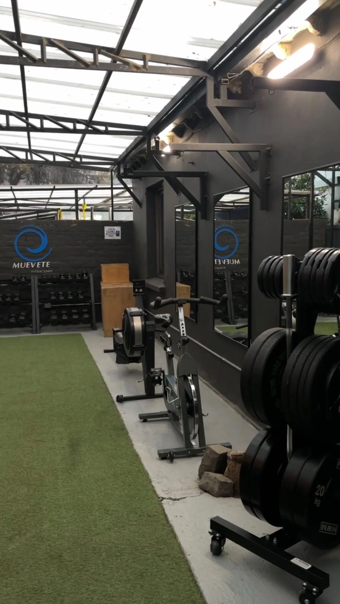 Zona de entrenamiento de Muévete, con racks, remos y muro de la marca